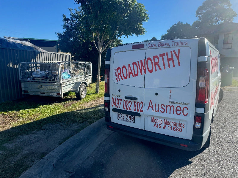 "Expert conducting a mobile safety certificate inspection on a trailer on a sidewalk in Alderley." Van with Ausmec Mobile Mechanics branding on a residential street