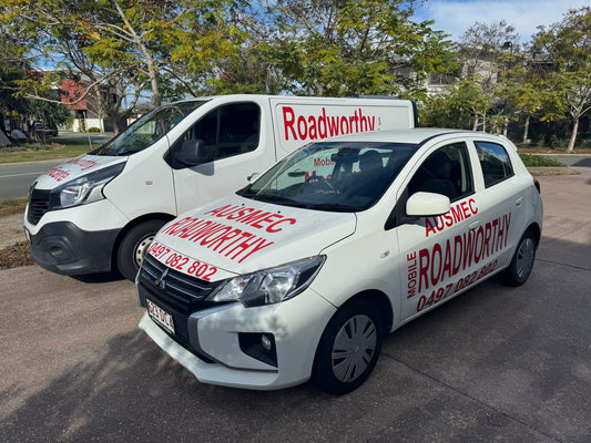 (Ausmec vehicles heading to do inspections): Two Ausmec Mobile Roadworthy vans, clearly branded, driving towards Chermside to perform mobile safety certificate inspections.
 Two white cars with 'Roadworthy' branding on a road.
