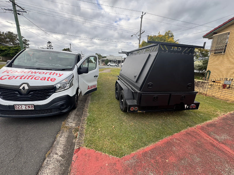 We inspect all types of vehicles for your Chermside West Mobile Roadworthy (Safety Certificate). This includes trailers, which we can conveniently inspect even on your grass, ensuring they're safe for the road. White van with 'Roadworthy Certificate' text and a black trailer on a residential street.
