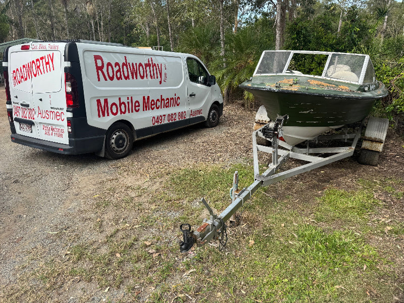 From cars to boat trailers, get your Clayfield Mobile Roadworthy (Safety Certificate) wherever it's convenient—even on your lawn! Roadworthy Mobile Mechanic van next to a boat on a trailer in an outdoor setting.