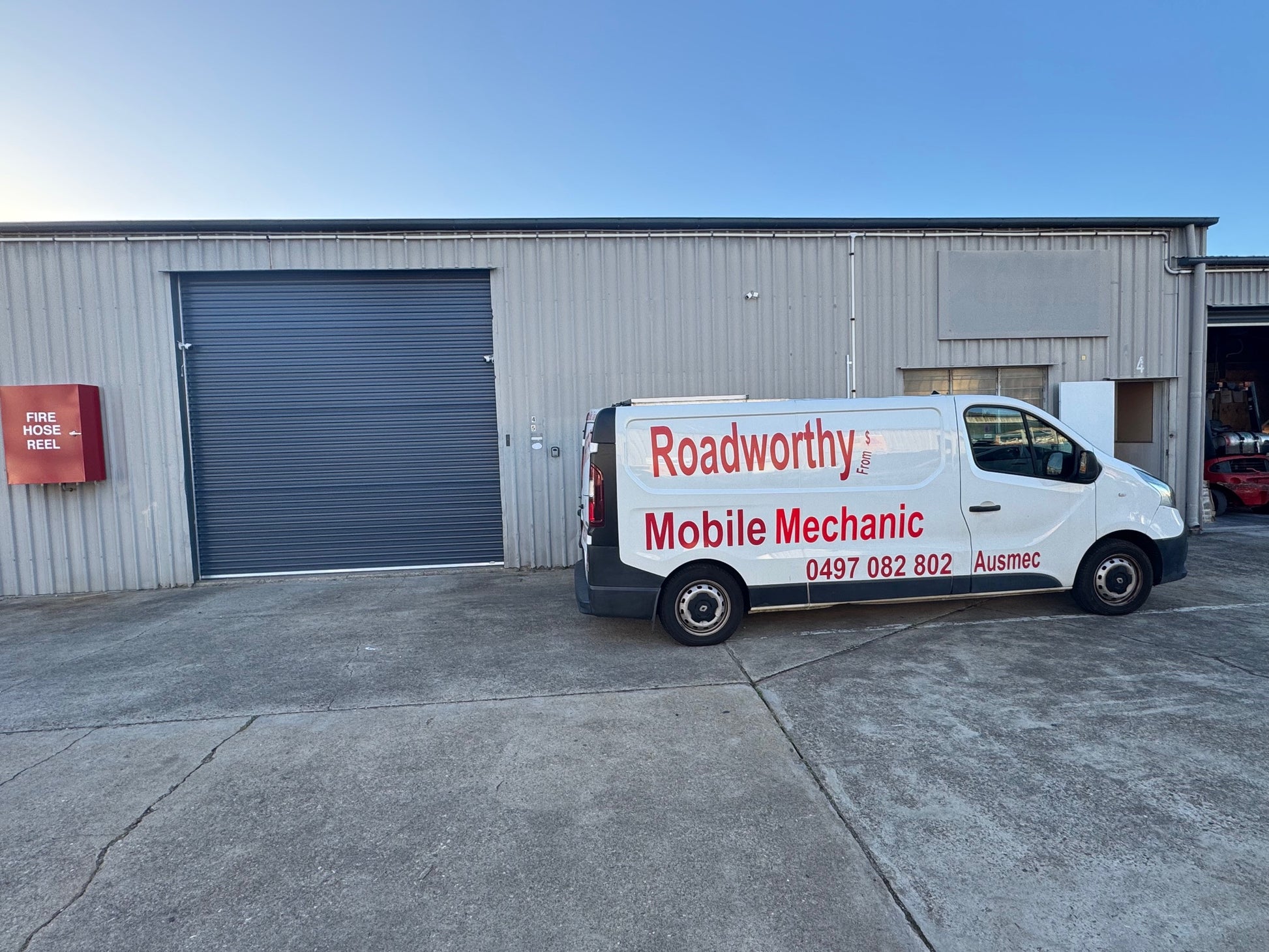 White van with 'Roadworthy Mobile Mechanic' branding parked outside a building.A general shot of a Murrumba Downs automotive workshop with a prominent sign indicating services, including Murrumba Downs Roadworthy (Safety Certificate) issuance.