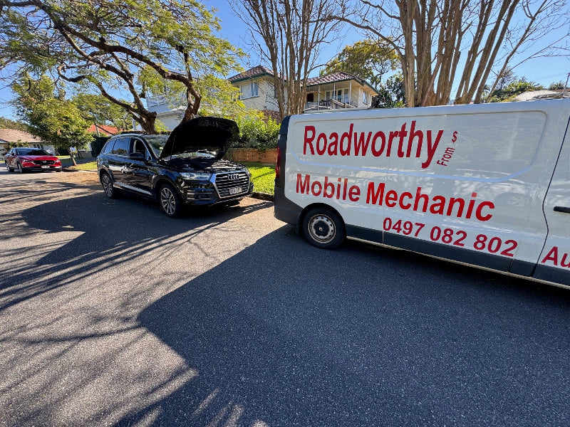 "Our mechanic performing an in-depth engine inspection on an Audi for a Murrumba Downs Mobile Roadworthy (Safety Certificate)."Mobile mechanic van with open car hood on a residential street