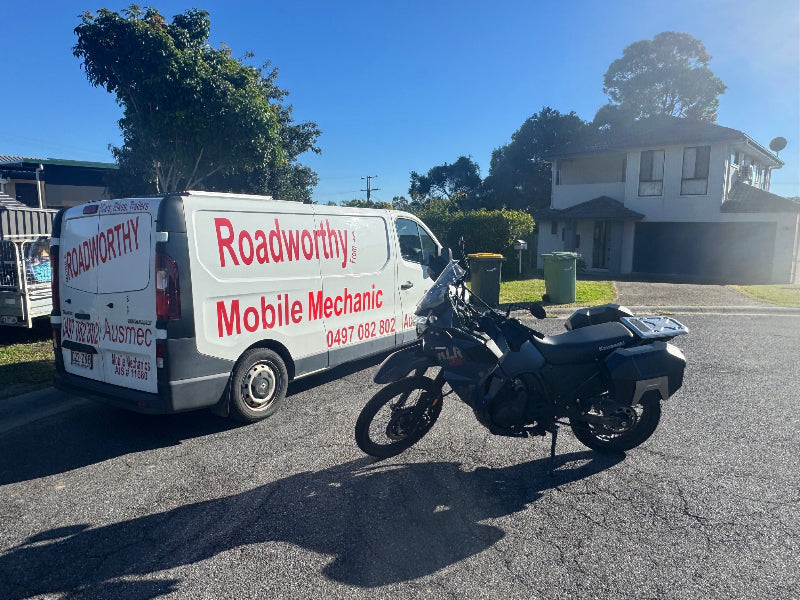 "Offroad motorcycle receiving essential Caboolture South Mobile Roadworthy (Safety certificate) for transfer by expert mechanic." Roadworthy mobile mechanic van with a motorcycle on a residential street.