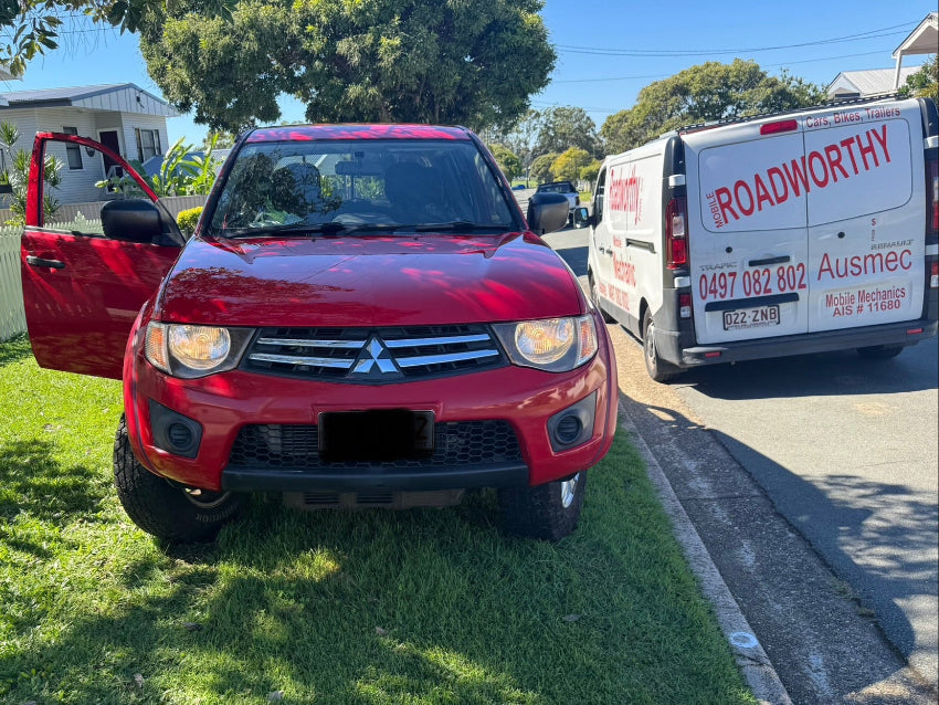 Our roadworthy van is visible next to a red Triton ute being inspected for its Margate Roadworthy (Safety Certificate)."