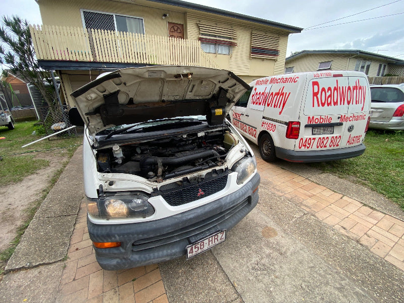 Even classic vehicles need a Zillmere Mobile Roadworthy (Safety Certificate) – We inspect all makes and models with precision.Car with open hood on a driveway, Roadworthy van in the background