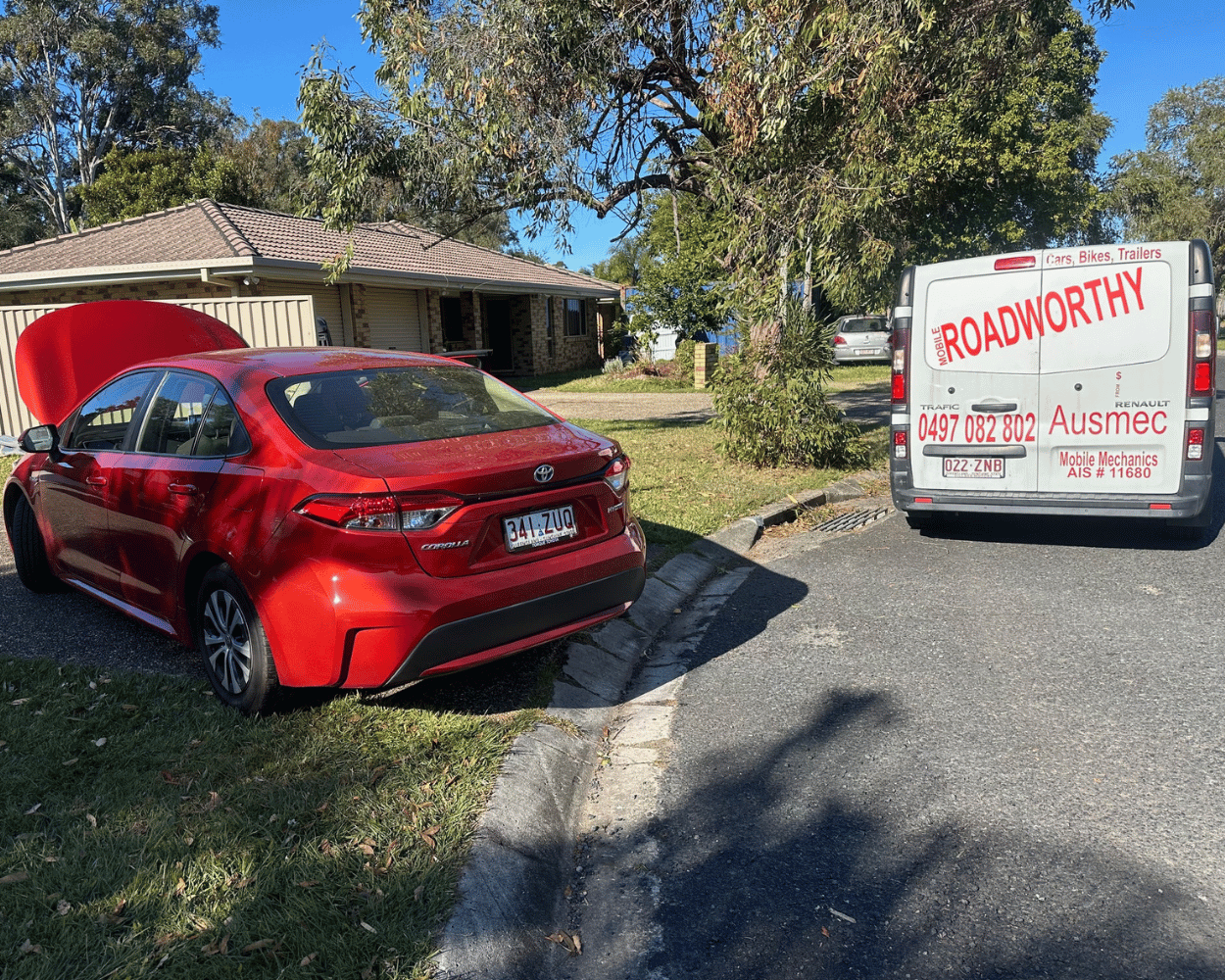 "Ensuring your vehicle's safety with a comprehensive Taigum Mobile Roadworthy (Safety Certificate)." Red car with open hood on a driveway next to a van with 'Roadworthy' signage.