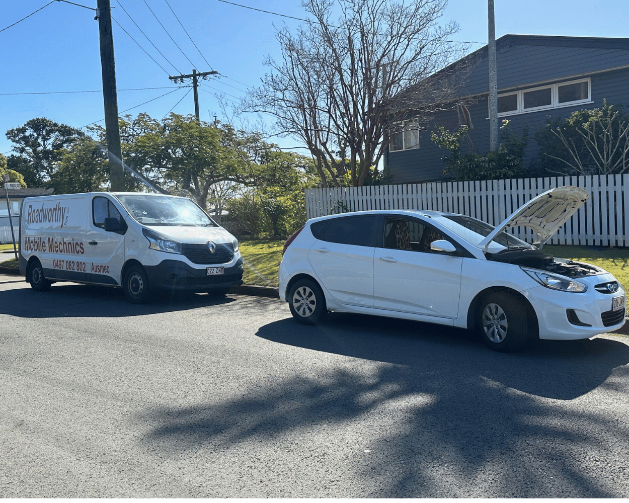 "Customer's car receiving a convenient Burpengary East Mobile Roadworthy (Safety Certificate) at their home." White van and car on a residential street with a clear sky.