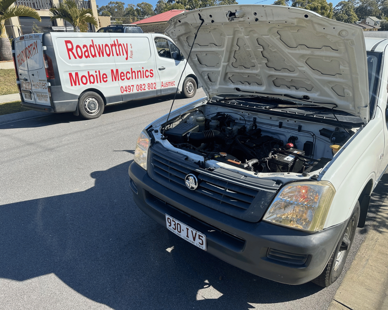 "Ausmec Mobile Mechanic conducting a Burpengary East Mobile Roadworthy (Safety Certificate) inspection on a ute on-site." Car with open hood on a road, with a Roadworthy Mobile Mechanics van in the background.