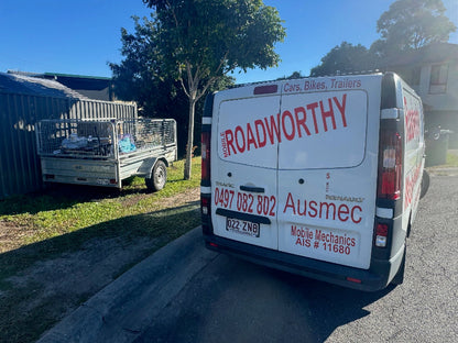  "Expert conducting a mobile safety certificate inspection on a trailer on a sidewalk in Alderley." Van with Ausmec Mobile Mechanics branding on a residential street