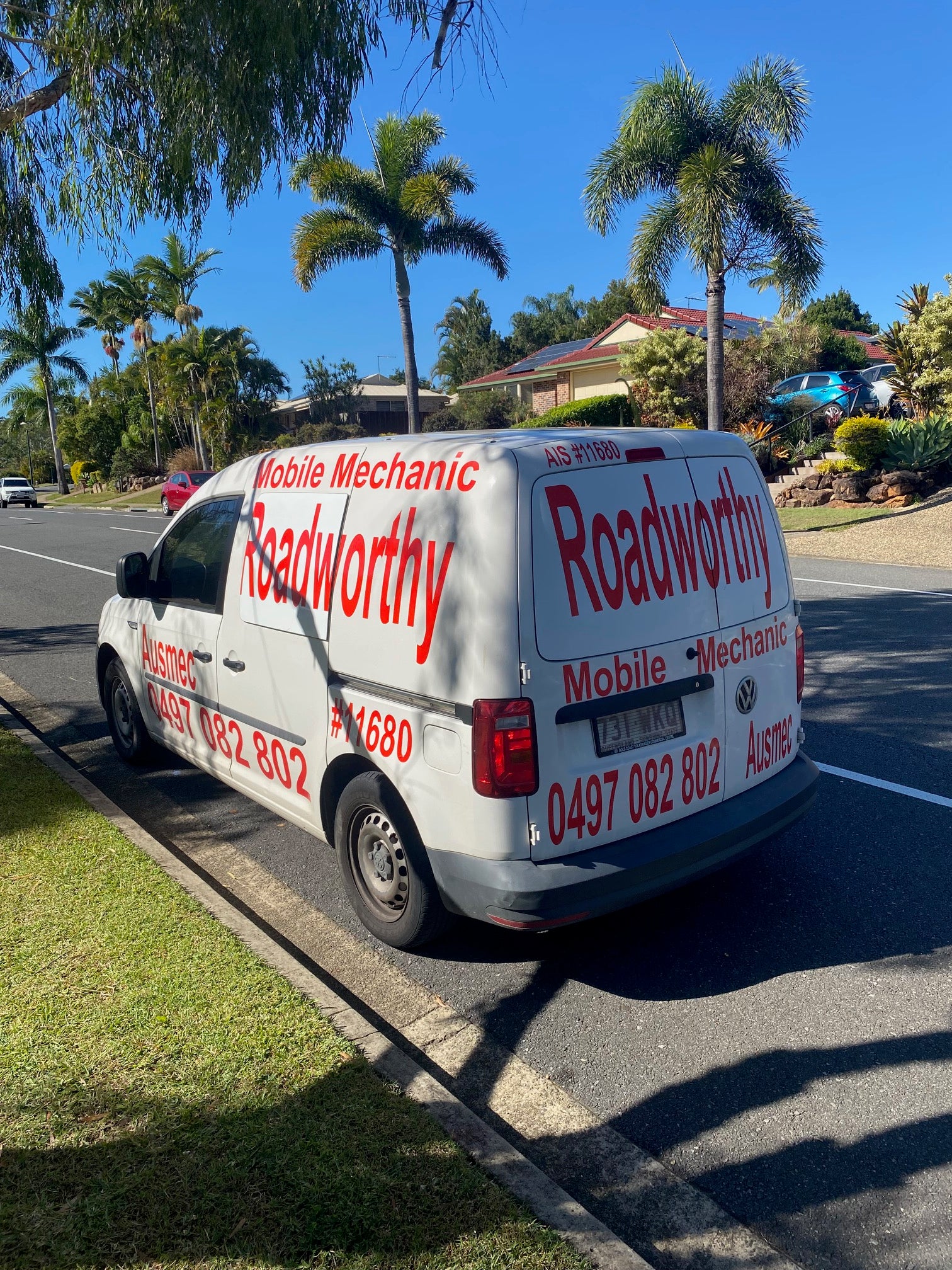 On our way to your Bracken Ridge Mobile Roadworthy (Safety Certificate)! Mobile mechanic van with 'Roadworthy' branding on a road with palm trees in the background.