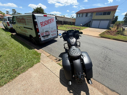 Motorcycle parked on a driveway with a van labeled 'Roadworthy' in the background in Dakabin