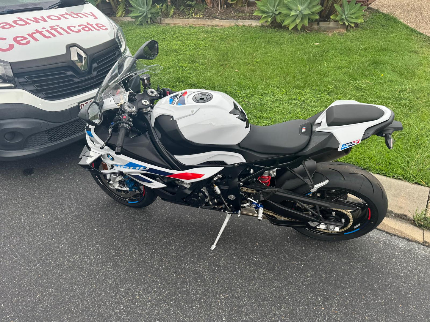 Motorcycle parked on a street with a grassy area and a Roadworthy vehicle in the background in Everton Park