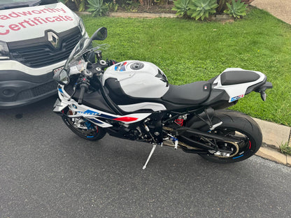 Motorcycle parked on a street with a grassy area and a Roadworthy vehicle in the background in Everton Park