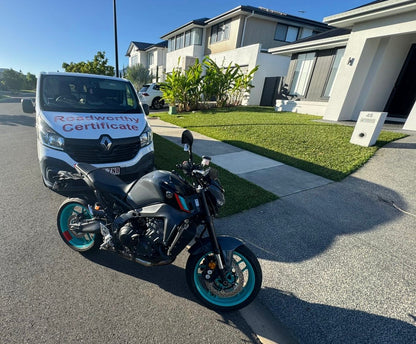 Motorcycle parked on a driveway with a Roadworthy van in the background displaying a 'Roadworthy Certificate' in Clontarf