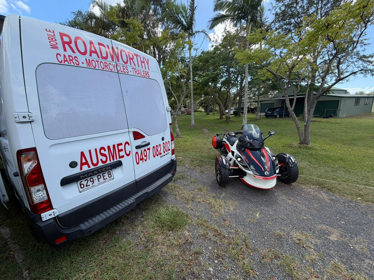 Van with 'Roadworthy' and 'AUSMEC' branding next to a three-wheeled vehicle on a grassy area in Petrie