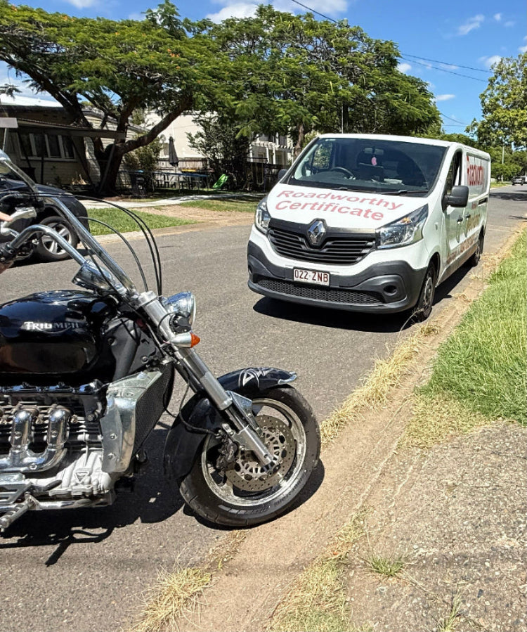 Motorcycle parked on the side of a road with a van in the background in Kurwongbah