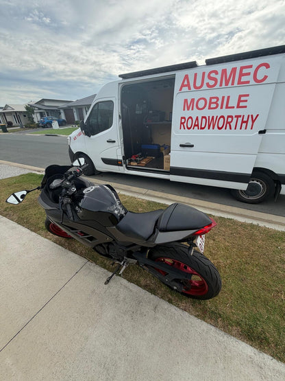 Motorcycle parked on a driveway with an Ausmec Mobile Roadworthy van in the background in Mango Hill