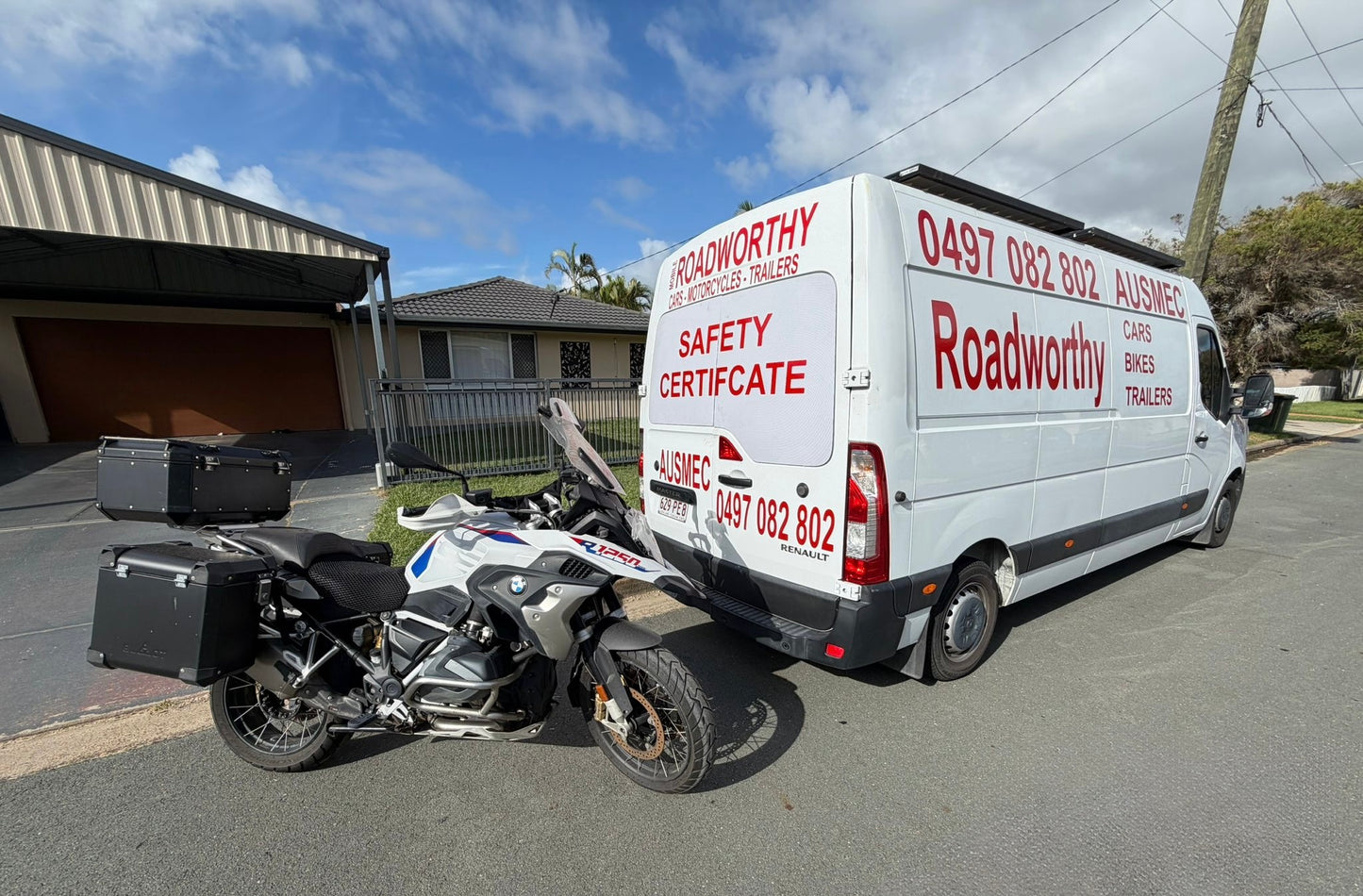 Van with 'Roadworthy' branding next to a motorcycle on a residential street in Newport