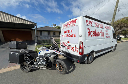 Van with 'Roadworthy' branding next to a motorcycle on a residential street in Newport