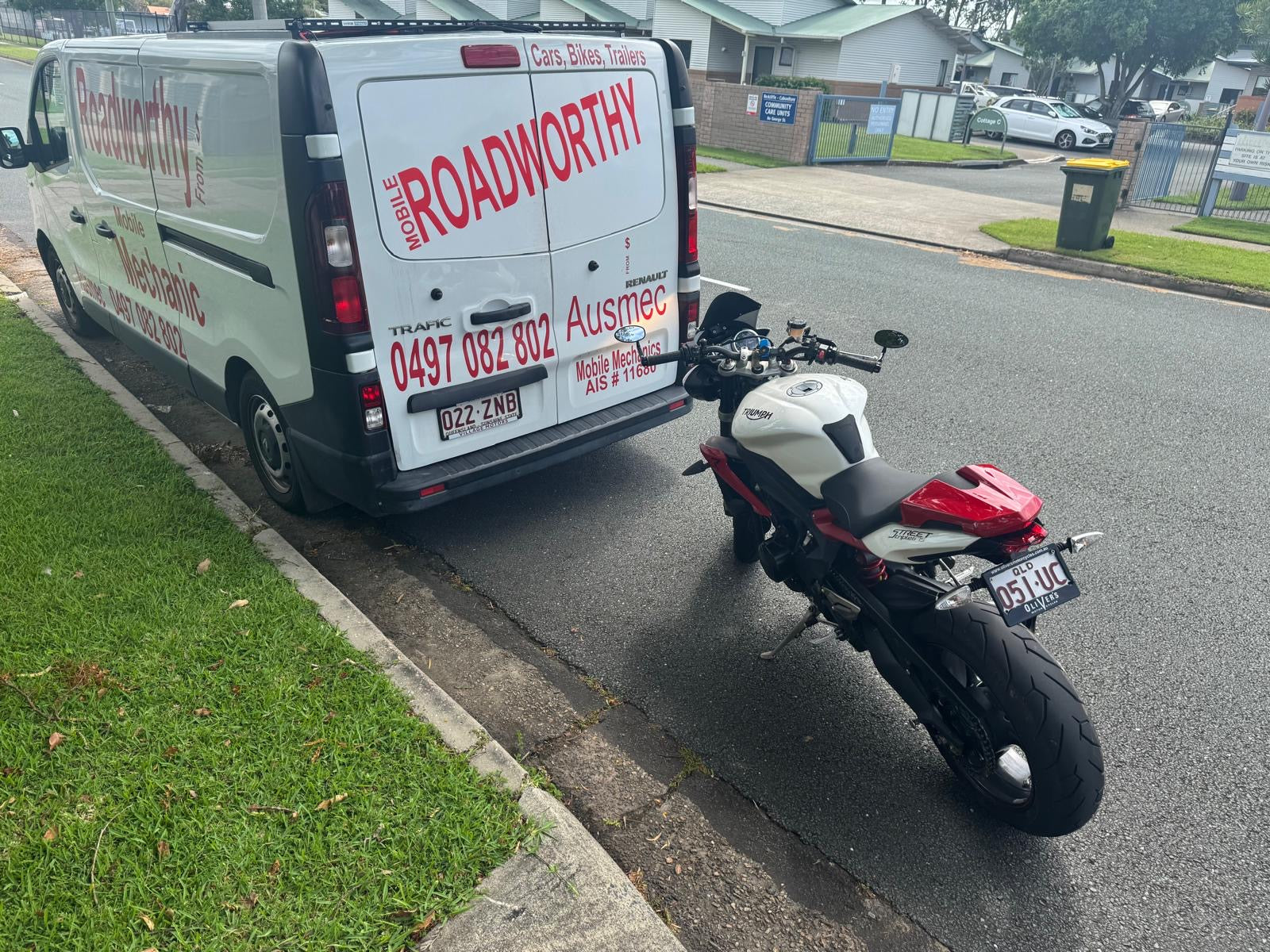 Van with 'Roadworthy' branding towing a motorcycle on a residential street in Everton Hills