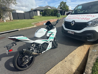 Motorcycle parked on a residential street with a van in the background in Hamilton