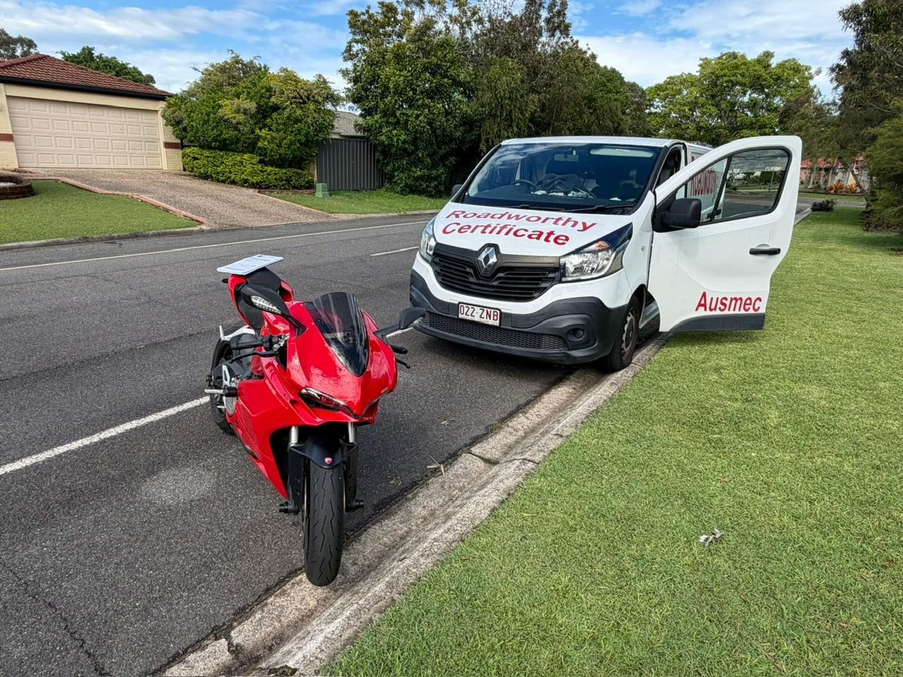 White van with 'Ausmec' branding next to a red motorcycle on a residential  street in Kelvin Grove