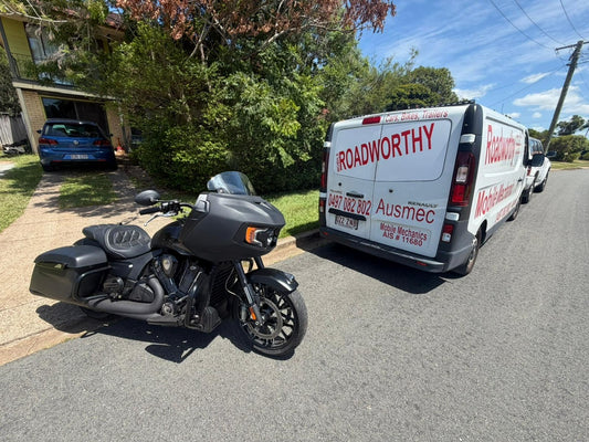 Motorcycle parked on a residential street with a van labeled 'Roadworthy' in the background in Narangba