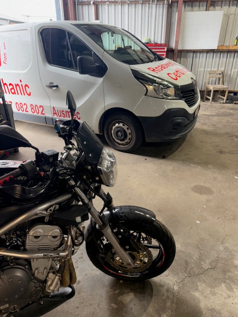 Motorcycle and Roadworthy vehicle on their sides in a garage in Nundah