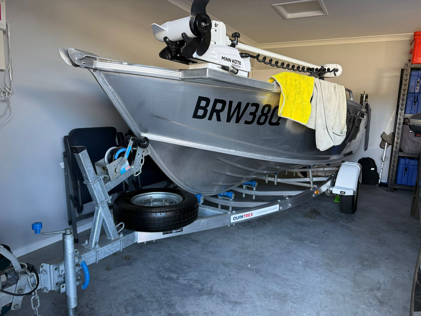 A boat on a trailer, positioned inside a customer's garage, is prepared for an upcoming North Lakes Mobile Roadworthy (Safety Certificate) inspection, demonstrating our ability to inspect various vehicle types in diverse locations."