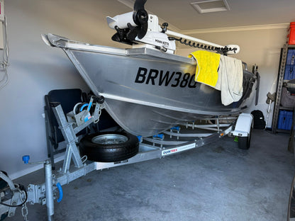 A boat on a trailer, positioned inside a customer's garage, is prepared for an upcoming North Lakes Mobile Roadworthy (Safety Certificate) inspection, demonstrating our ability to inspect various vehicle types in diverse locations."