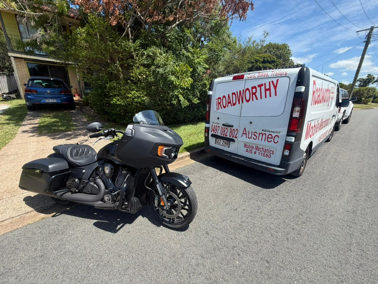 Motorcycle parked on a residential street with a van labeled 'Roadworthy' in the background in Scarborough