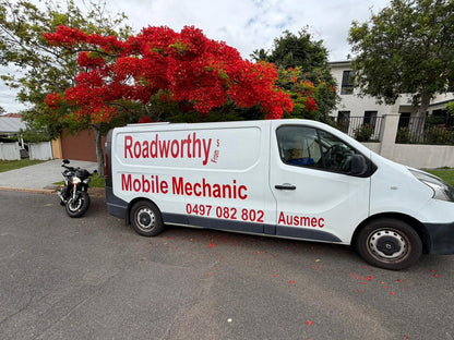 Roadworthy mobile mechanic van parked on a street with a red flowering tree in the background in Stafford