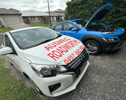 "Blue Hyundai receiving convenient Caboolture South Mobile Roadworthy (Safety certificate) car inspection at customer's home." Two cars, one with 'Ausmee Roadsvc' branding, parked on a residential street.