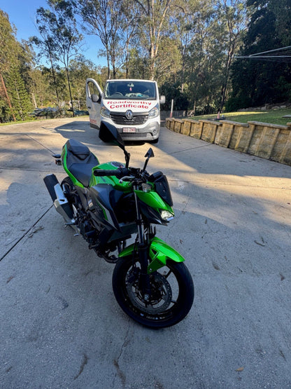 Motorcycle inspection in road
Alt text: Thorough mobile roadworthy inspection of a motorcycle on location for a Wavell Heights customer seeking a safety certificate. Green motorcycle parked on a road with trees and a building in the background