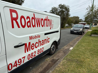 Mobile van ready to inspect: "Ausmec Mobile Roadworthy van, fully equipped and ready to provide a Safety Certificate inspection in Woody Point." White van with 'Roadworthy Mobile Mechanic' branding on a residential street.